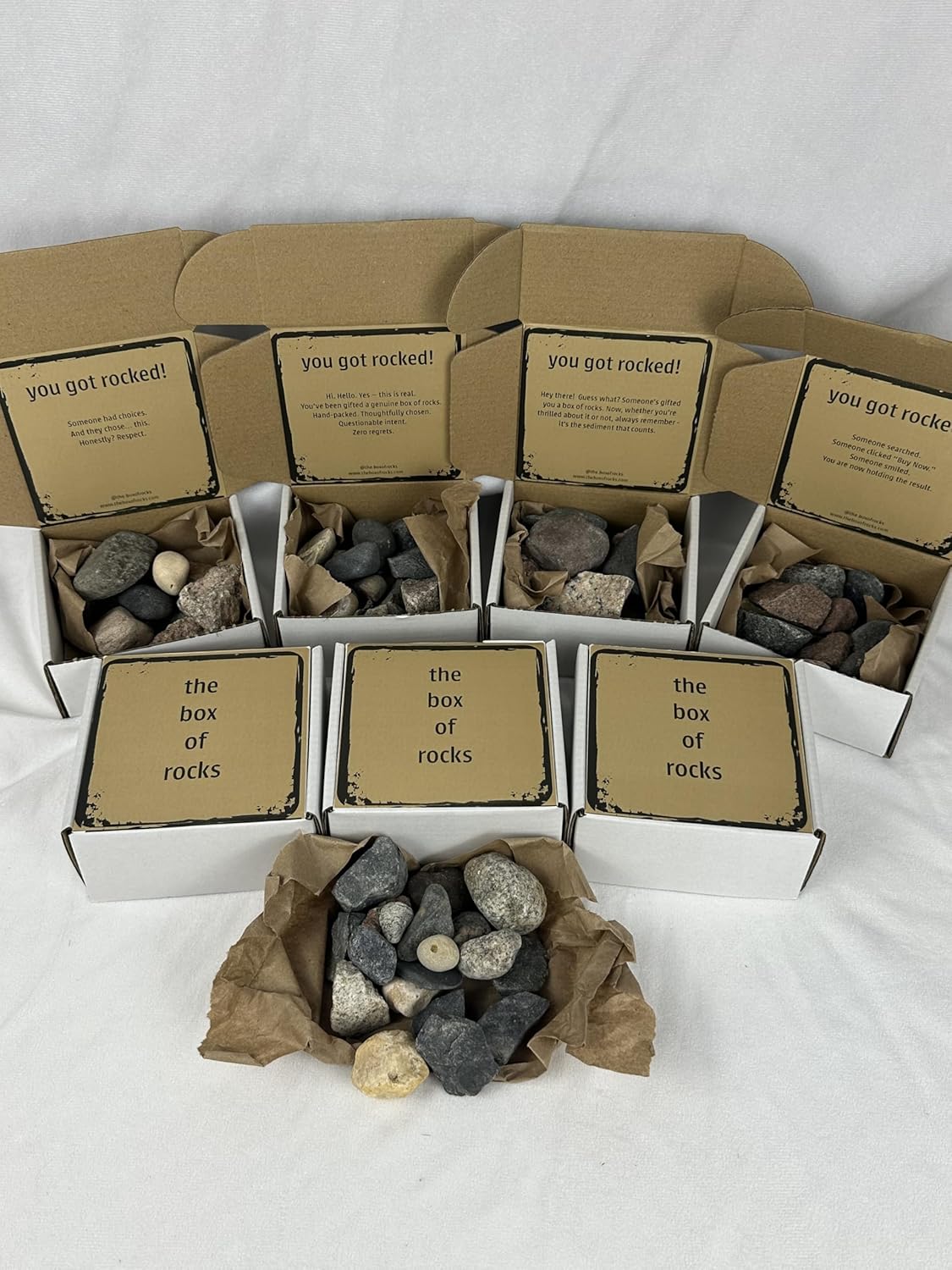 Several packed Box of Rocks gifts showing different message cards and natural rock assortments